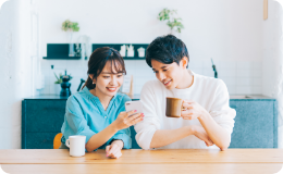 携帯を一緒に見る女性と男性