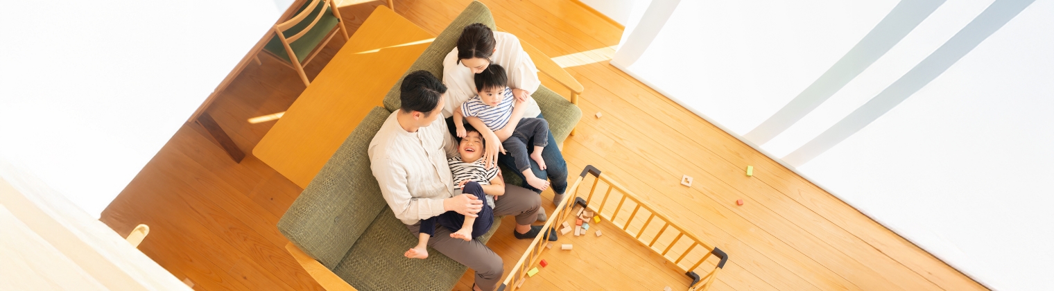 上から撮影したリビングに座っている4人家族の写真